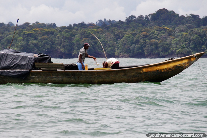 Pescador arroja un pez en un cubo frente a la costa de Buenaventura. (720x480px). Colombia, Sudamerica.