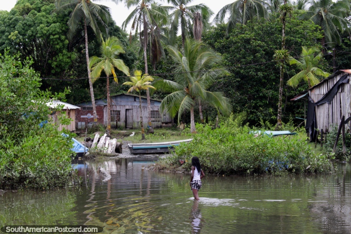 Local girl of Juanchaco walks through the water to a wooden house in the jungle, Buenaventura. (720x480px). Colombia, South America.