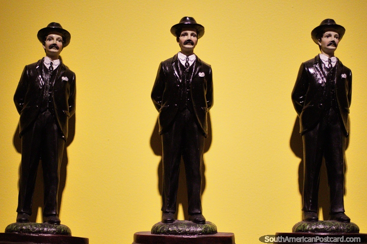 3 men in black suits and hats, do they sing or dance? Antiques at Antioquia Museum, Medellin. (720x480px). Colombia, South America.