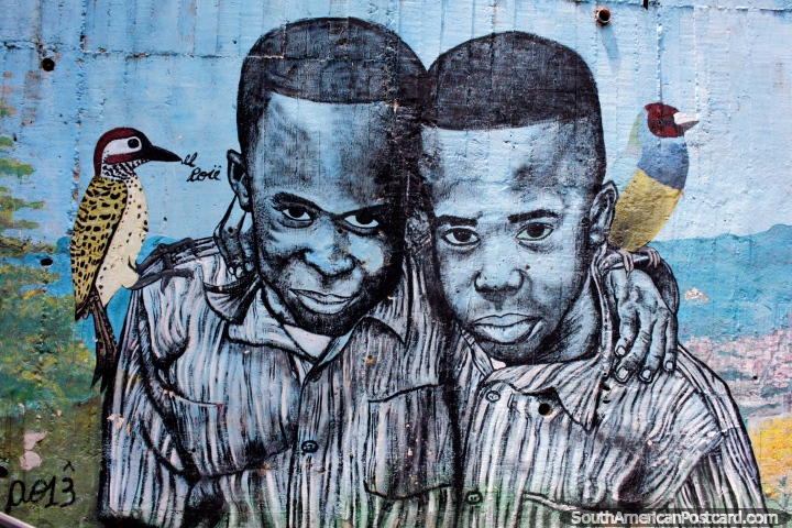 2 brothers, each with a bird, worn street art in Comuna 13, Medellin. (720x480px). Colombia, South America.