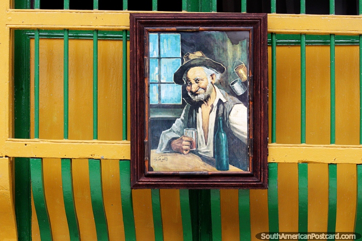 Man having a drink, painting outside a shop in Jardin. (720x480px). Colombia, South America.