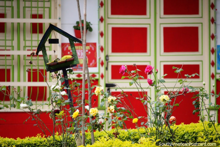 Jardim de rosas e fachadas coloridas, vista do parque central em Jardin. (720x480px). Colômbia, América do Sul.