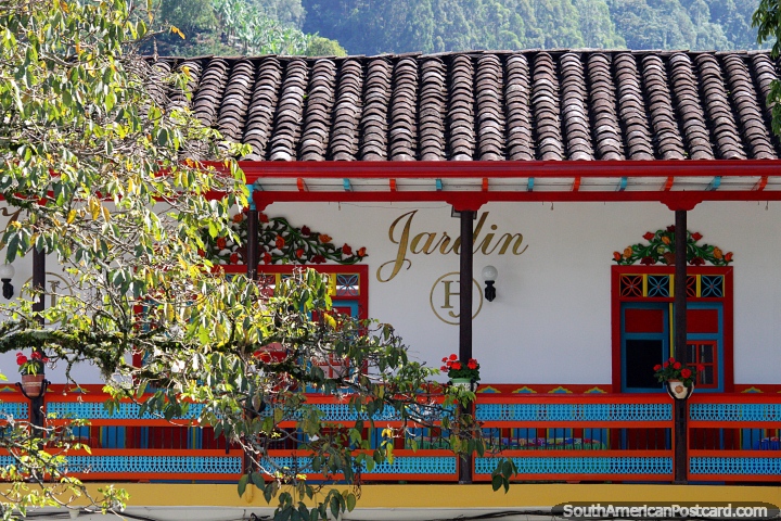 Balcón de madera colorido bajo un techo de tejas, una característica icónica de Jardin. (720x480px). Colombia, Sudamerica.