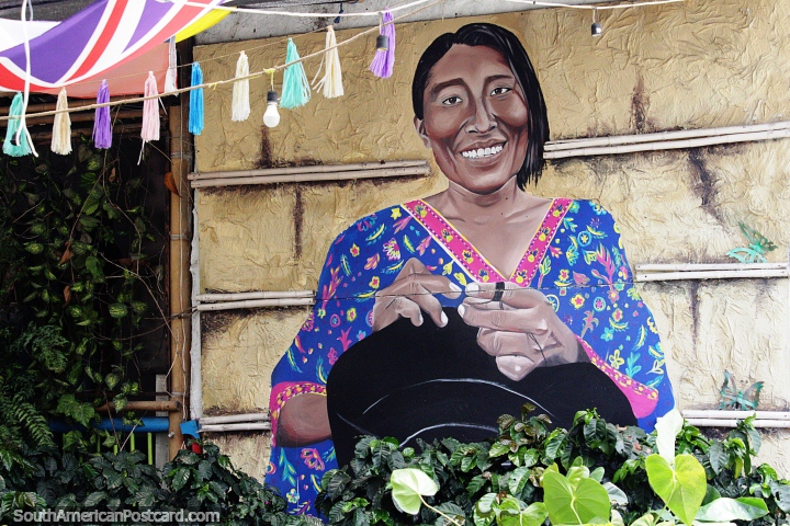 Mulher indgena com vestido roxo costurando um chapu, mural em Salento. (720x480px). Colmbia, Amrica do Sul.