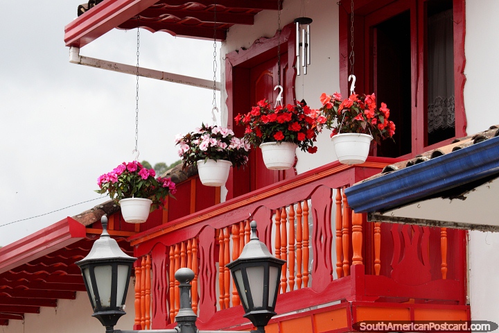 Beautiful red balcony with flower pots, nicely decorated house in Salento. (720x480px). Colombia, South America.