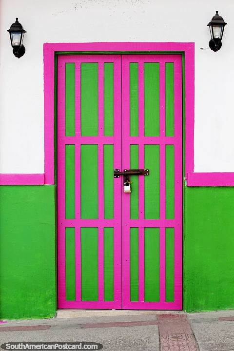 Par de farolas encima de una puerta y pared rosa y verde en Salento. (480x720px). Colombia, Sudamerica.