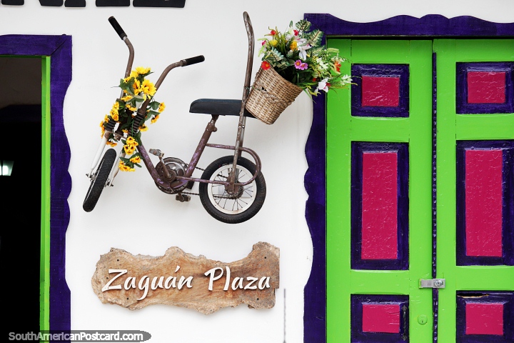 Bicicleta decorada com flores, um portal colorido, uma bela fachada na Zaguan Plaza, Salento. (720x480px). Colmbia, Amrica do Sul.
