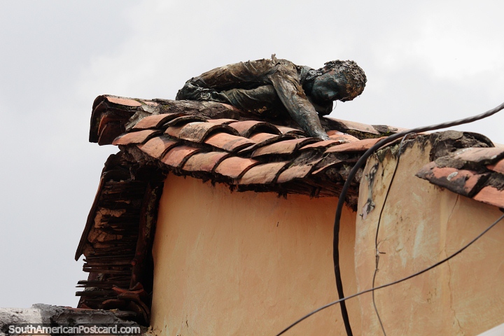 Não é um cadáver apodrecido, isso é arte, uma figura de bronze em um telhado de telhas vermelhas em La Candelaria, Bogotá. (720x480px). Colômbia, América do Sul.