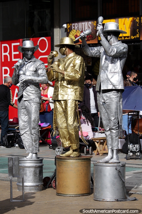 3 hombres vestidos totalmente de plata y oro bailan y bailan en la calle de Bogot. (480x720px). Colombia, Sudamerica.