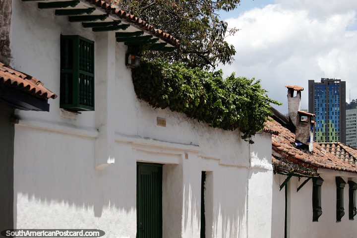 Casas de sebe espessa e branca, chamins e um edifcio moderno distante, Bogot. (720x480px). Colmbia, Amrica do Sul.