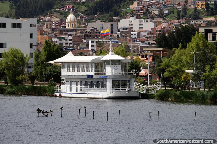 View of Paipa from across Lake Sochacota, cruise boat and a distant church. (720x480px). Colombia, South America.