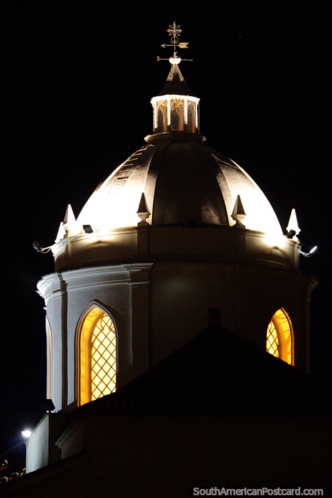 A catedral à noite, uma luz amarela brilha nas janelas em arco da cúpula em Tunja. (480x720px). Colômbia, América do Sul.