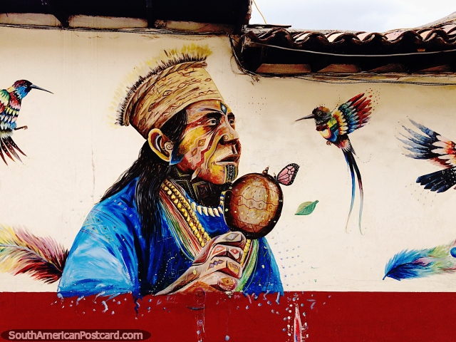 Beija-flores se aglomeram ao redor de um homem indígena com uma borboleta, mural de rua em Sogamoso. (640x480px). Colômbia, América do Sul.