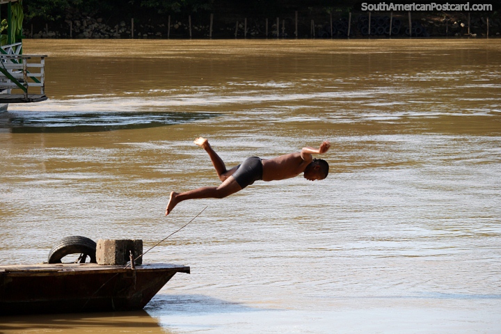 O menino local de Monteria mergulha no rio Sinu em um dia quente. (720x480px). Colômbia, América do Sul.
