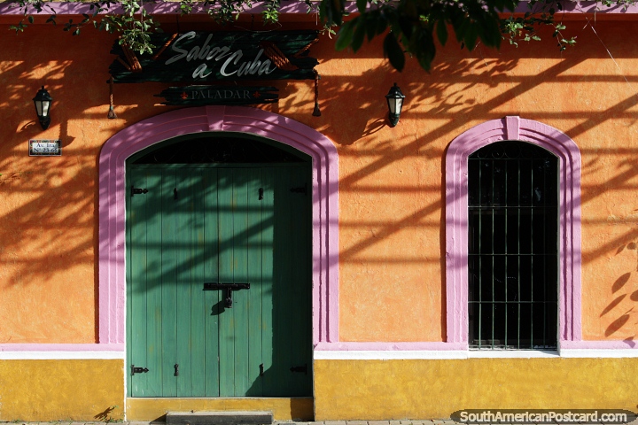 Fachada de laranja, rosa, verde e amarelo, um restaurante que se destaca em Monteria. (720x480px). Colômbia, América do Sul.