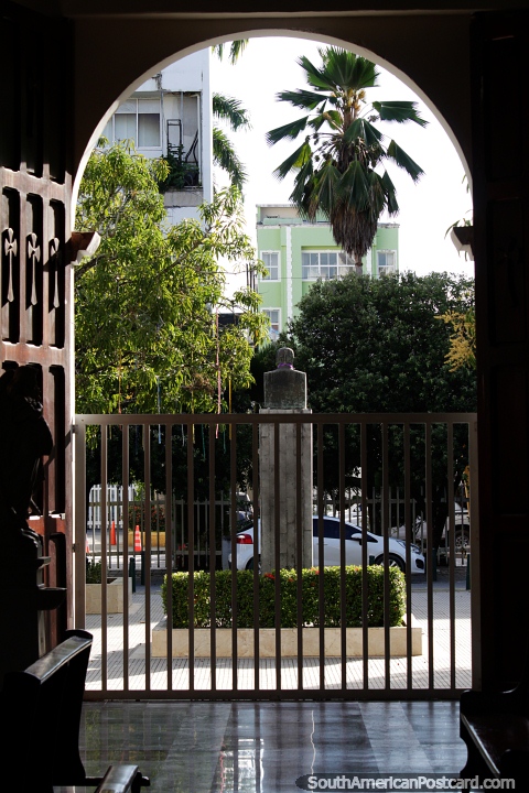 O parque fora da catedral em Monteria, vista através de uma porta em arco. (480x720px). Colômbia, América do Sul.