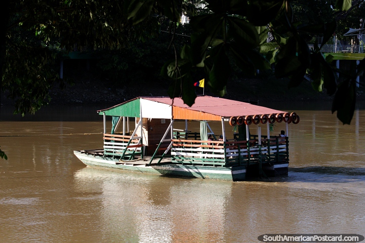 Os barcos-plataforma cruzam o rio Sinu regularmente, levando as pessoas de um lado para o outro em Monteria. (720x480px). Colômbia, América do Sul.