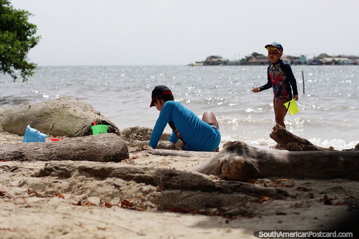 Los niños juegan en la arena de una de las muchas playas de las bahías de la isla de Tintipán. (720x480px). Colombia, Sudamerica.