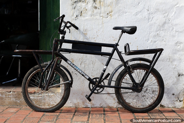 Uma bicicleta antiga está encostada na parede do lado de fora de uma loja de antiguidades em Mompos. (720x480px). Colômbia, América do Sul.
