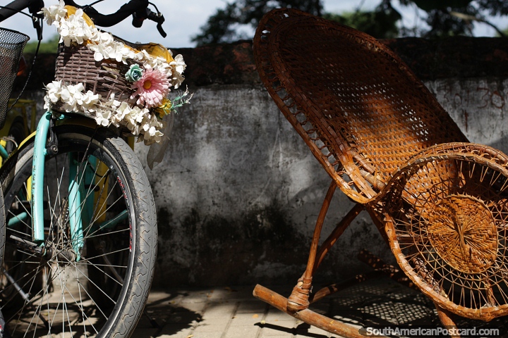Bicicleta com cesto de flores e cadeira de balanço em cana, ícones de Mompos à beira do rio. (720x480px). Colômbia, América do Sul.