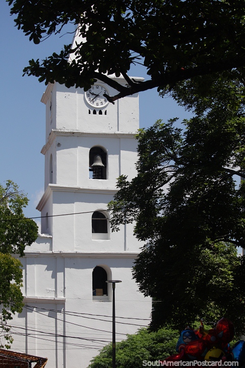 White colonial church (a national monument) in Neiva, rebuilt in 1791, tower with bells and clock. (480x720px). Colombia, South America.
