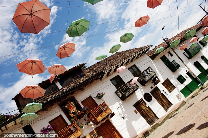 Rua dos guarda-chuvas em San Agustín, vista espetacular com guarda-chuvas rosa e verdes acima. (720x480px). Colômbia, América do Sul.