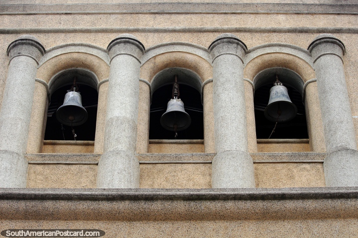 3 large bells between stone columns, an historic building in Pamplona beside the plaza. (720x480px). Colombia, South America.