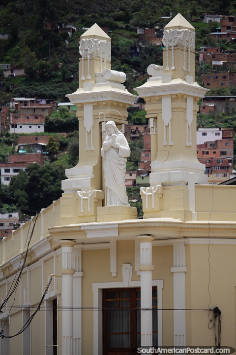 Jesús se encuentra entre dos altas columnas en lo alto de un edificio histórico de Pamplona. (480x720px). Colombia, Sudamerica.