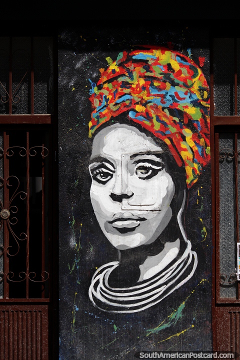 Woman with bright multicolored head-wear, street art in Pamplona. (480x720px). Colombia, South America.