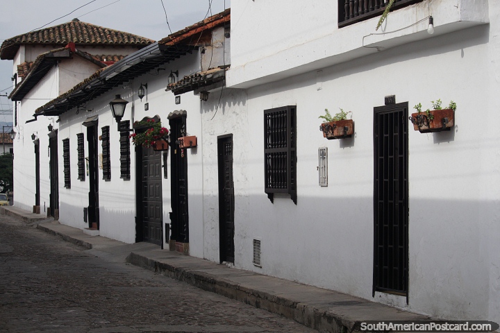 Rua e casas em Giron com paredes caiadas de branco e vasos de flores, 10kms de Bucaramanga. (720x480px). Colômbia, América do Sul.