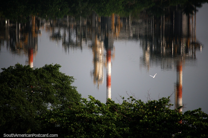 Chaminés altas da usina de petróleo Barrancabermeja refletindo no rio Magdalena. (720x480px). Colômbia, América do Sul.