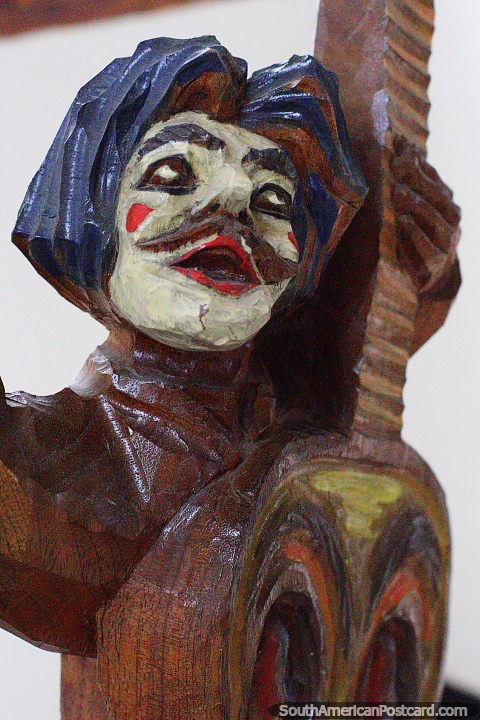 La turumama y los compinches (1996), talla en madera de un payaso tocando la guitarra, museo en Pasto. (480x720px). Colombia, Sudamerica.