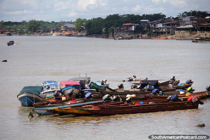 Boats in a group and wooden houses on the banks of the Atrato River in Quibdo. (720x480px). Colombia, South America.