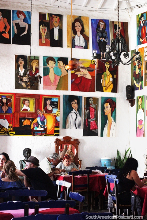 Painted portraits cover the walls of Restaurant El Porton del Parque in Santa Fe de Antioquia. (480x720px). Colombia, South America.