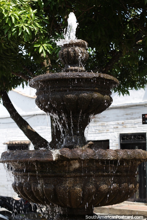Água jorra de uma fonte de pedra em uma praça em Santa Fé de Antioquia. (480x720px). Colômbia, América do Sul.