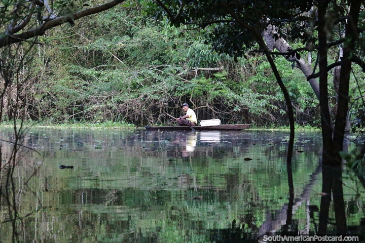 Pescadores amazónicos locales exploran el lago en una canoa de madera en Leticia. (720x480px). Colombia, Sudamerica.