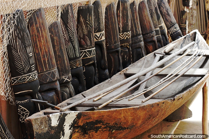 Row of wooden masks beside a canoe at the indigenous museum in Mocagua, Leticia. (720x480px). Colombia, South America.