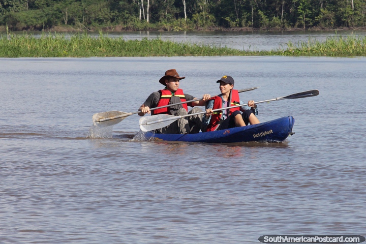 Um par rema um caiaque duplo no rio Amazonas em Mocagua, Letcia. (720x480px). Colmbia, Amrica do Sul.