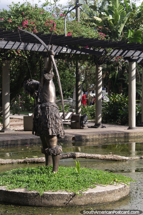 El hombre dispara un arco y una flecha, trabajo en bronce en el Parque Santander en Leticia. (480x720px). Colombia, Sudamerica.