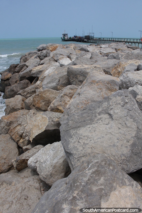 Spur of rocks and the dock on the seafront in Riohacha. (480x720px). Colombia, South America.