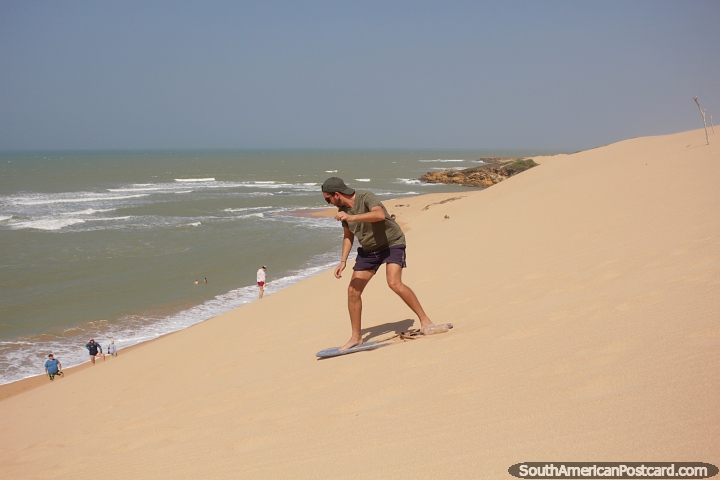 Standing up or sitting, enjoy sandboarding at the Taroa dunes in northern Guajira. (720x480px). Colombia, South America.