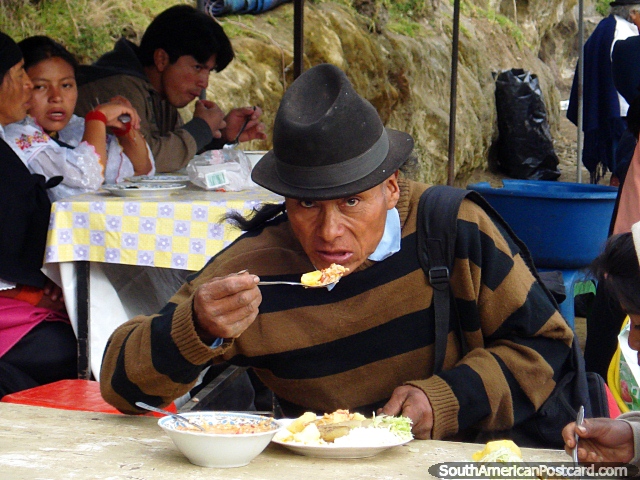 El hombre en el mercado de Otavalo come un plato grande de la comida para el desayuno. (640x480px). Ecuador, Sudamerica.