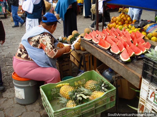A woman cuts up pineapple and watermelon in Otavalo. (640x480px). Ecuador, South America.