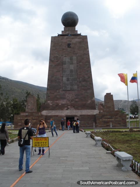 People taking photos standing on the equator line at Mitad del Mundo. (480x640px). Ecuador, South America.