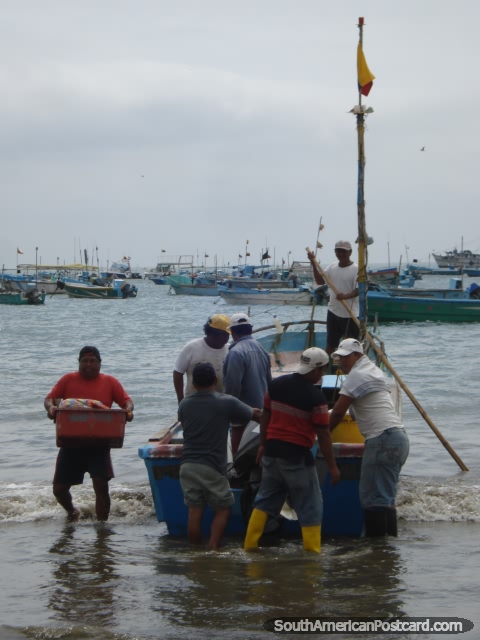 Pescadores que tiram barco em Porto Lopez. (480x640px). Equador, América do Sul.