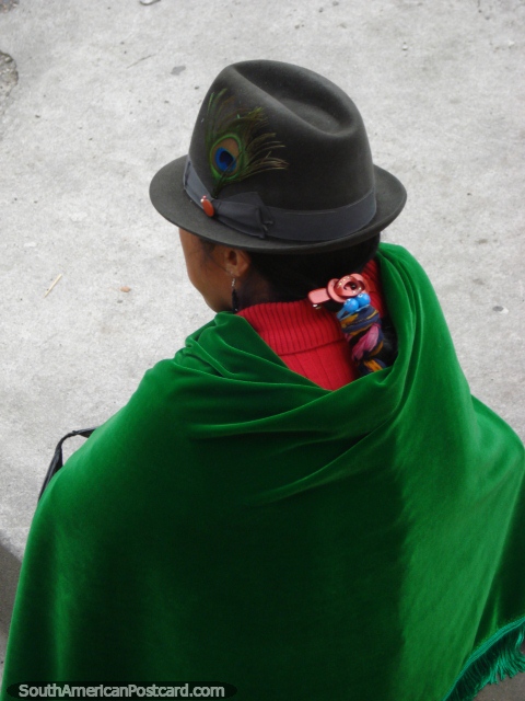 Uma mulher indïgena usa um chapéu com pena e xale verde em Banos. (480x640px). Equador, América do Sul.