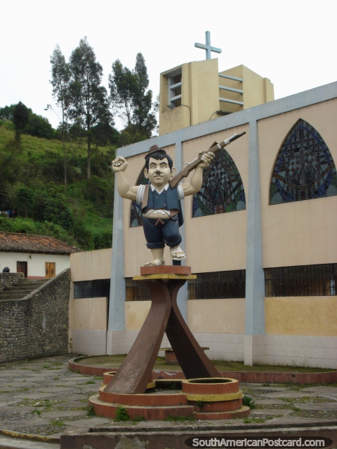 Pequeno homem com um monumento de arma junto de igreja em Tulcan. (480x640px). Equador, América do Sul.