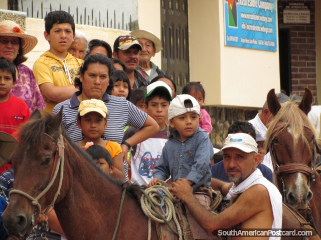 O rapaz em cavalo e multido olha atividades para o festival em Vilcabamba. (640x480px). Equador, Amrica do Sul.