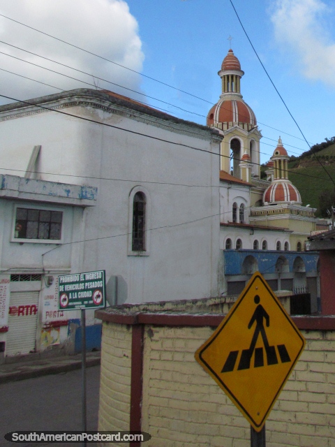 Igreja cor-de-laranja rosa, sinais e uma esquina de rua em Julio Andrade. (480x640px). Equador, América do Sul.