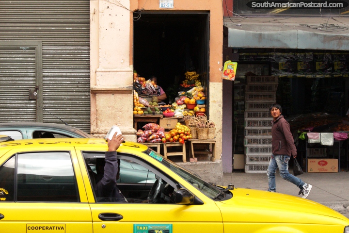 Fruit and vegetable shop, boy walks past, yellow taxi, Ambato. (720x480px). Ecuador, South America.